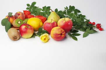 Naklejka na ściany i meble Fresh fruits apples, peaches, kiwi and leaves on a white background.