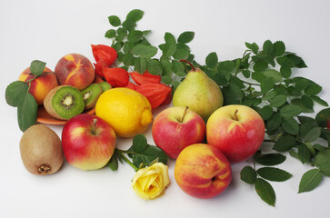 Fresh fruits apples, peaches, kiwi and leaves on a white background.