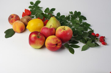 Fresh fruits apples, peaches, kiwi and leaves on a white background.