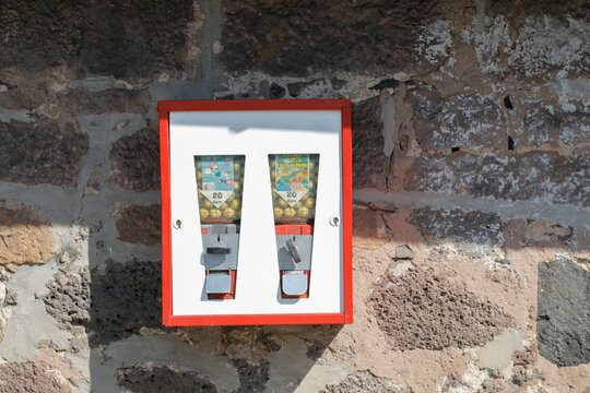 Chewing gum machine on a brick wall with shadow