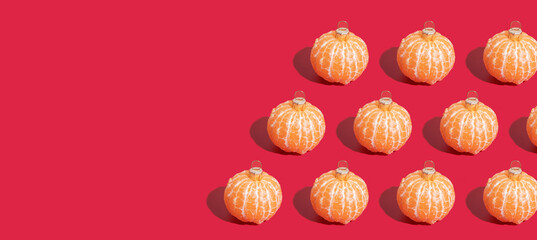 Banner with Mandarin pattern in the form of a Christmas tree toy on red background with copy space. Minimalistic christmas concept