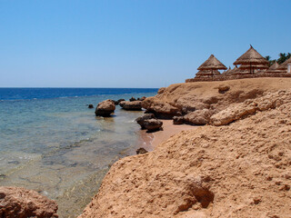 Beautiful view of the sea from a sandy beach with a rocky shore
