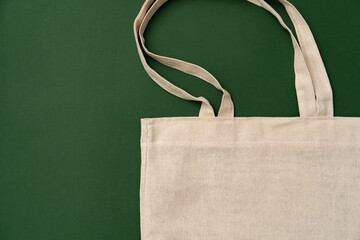Textile shopping bag on green background flat lay