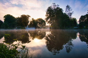A sunrise at dawn, with fog on the river and warm light atmosphere. Landscape shot