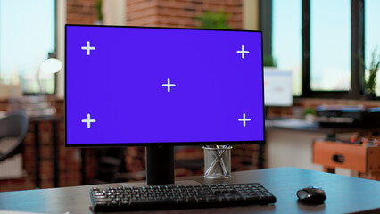 Nobody at desk with greenscreen template on computer monitor in business company office. Desktop with blank mockup background on display with isolated copyspace chroma key on pc.