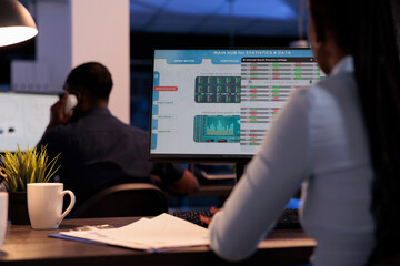Woman broker looking at real time stock market sales, analyzing global trade exchange statistics for capital money investment. Working with hegde fund index profit on forex trading at night.