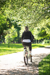 Fototapeta premium A woman in black jacket on a bike