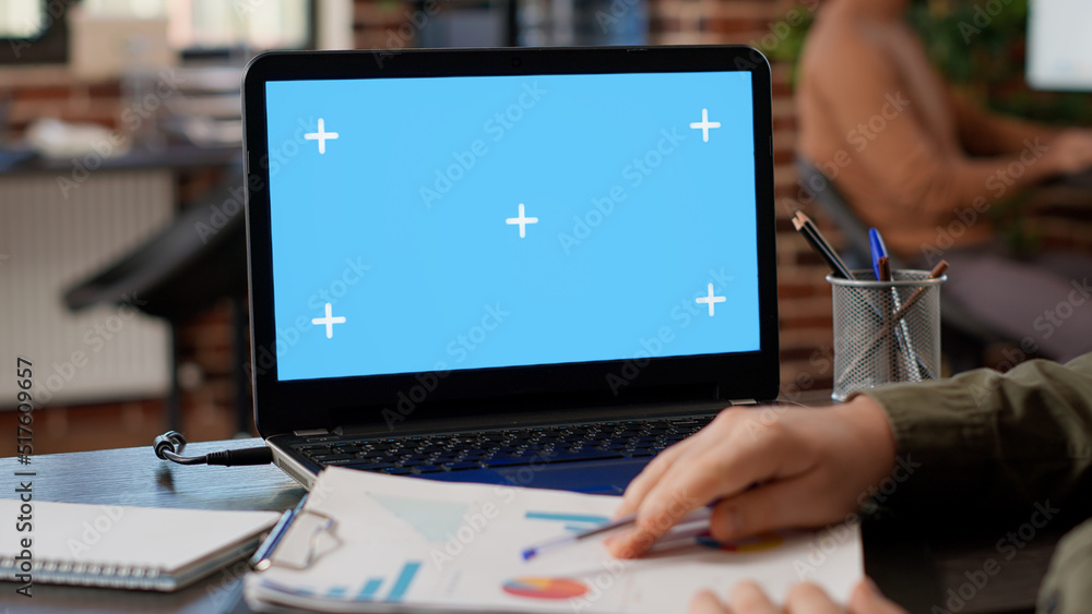 Poster male freelancer analyzing business charts and greenscreen on laptop, using blank chroma key display 