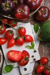 The harvest of assorted tomatoes, basil, spices, zucchini. Organic vegetables fresh from market. Top view
