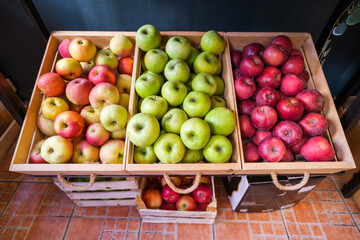 Healthy fruit and vegetables in grocery shop. Close up of baskets with various sorts of apples in supermarket.