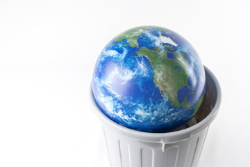 ゴミ箱に入った地球儀。環境問題イメージ