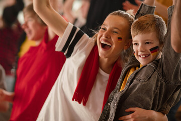 Young German football fans celebrating their team's victory at stadium.