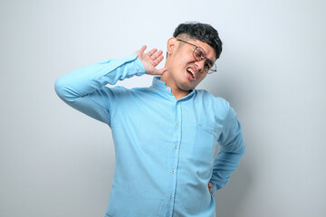 Young handsome asian man stretching back, tired and relaxed, sleepy and yawning for early morning