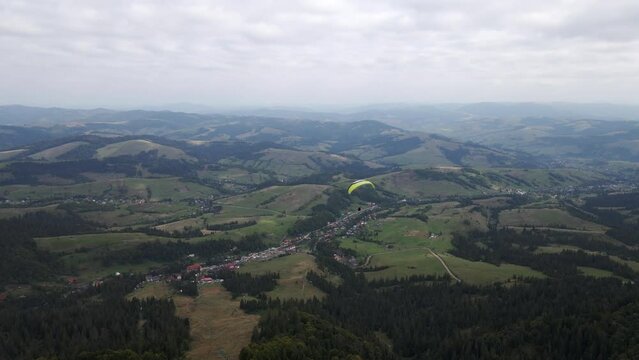 following after paraglider flying above ukrainian carpathian mountains