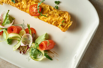 Omelet with avocado mousse and salmon in a plate. Selective Focus. Noise in post-production
