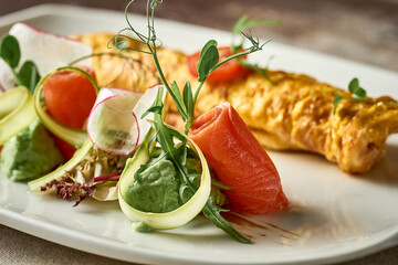 Omelet with avocado mousse and salmon in a plate. Selective Focus. Noise in post-production