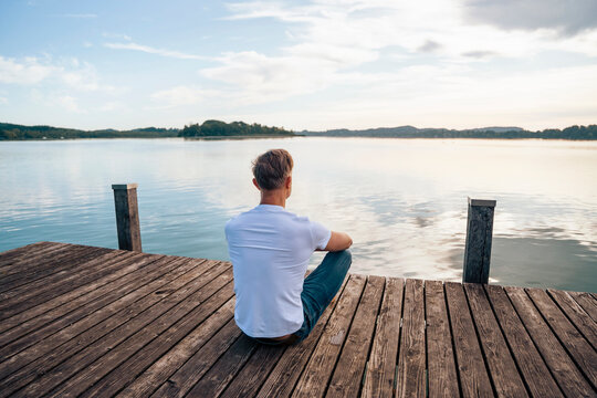 Man looking at scenic view from pier over lake