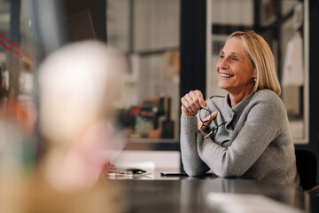 Happy mature businesswoman sitting at desk in office
