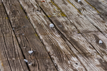 Obraz premium Small balls of hail, ice and hailstones from the sky on an old wooden table on a sunny day. Summer.