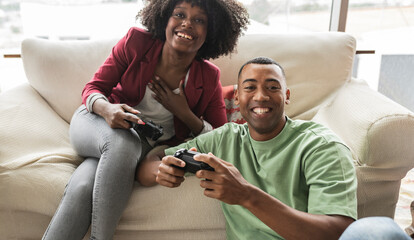 Happy young woman playing video game with man