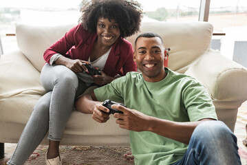 Smiling young woman playing video game with man