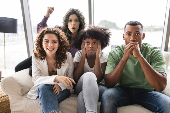 Excited Friends Sitting On Sofa Together