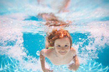Child in pool in summer day. Kid swimming in pool underwater. Child boy swim under water in sea.
