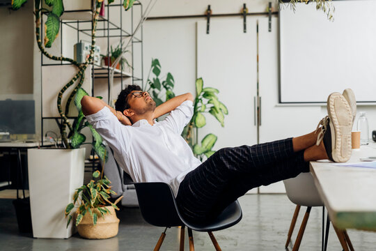 Young businessman relaxing on chair at office