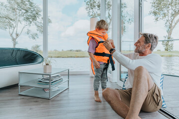 Father adjusting life jacket for son at home