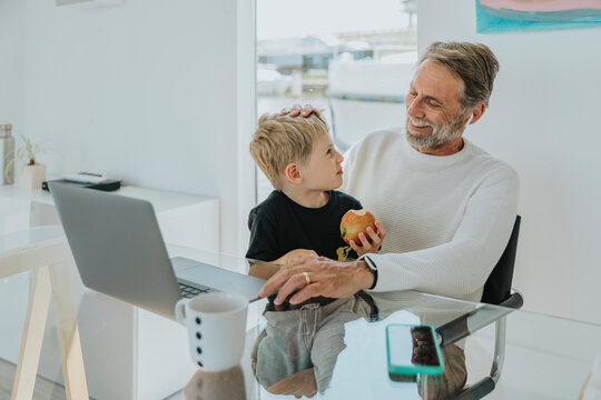 Happy father with son sitting at table