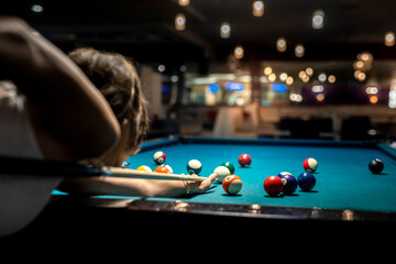 female player playing pool and aiming the billiard ball with cue - obrazy, fototapety, plakaty