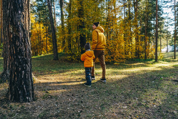 Fototapeta premium Father and son walking in autumn forest.