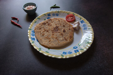 Indian breakfast item aloo paratha or potato stuffed flatbread served. Close up, selective focus.