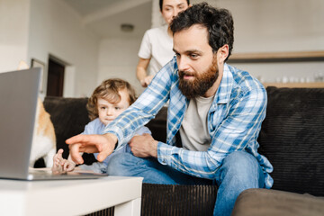 Fototapeta premium Smiling family on a video call via laptop computer