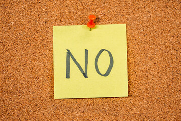 Yellow Post-it Sticky Note on a cork board with drawing pin. No