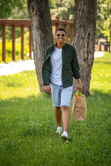 Man walking with food bag looking at camera