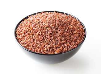 Uncooked red rice in black bowl isolated on white background with clipping path
