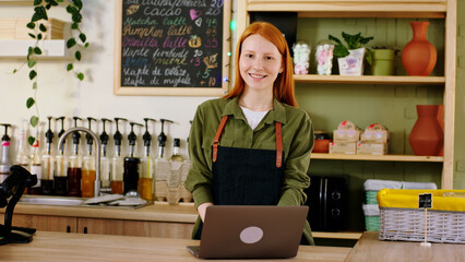 Black guy barista closeup to the camera working at the coffee shop together with his colleague on the background make a caffe for some customer