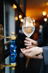 a girl with a glass of white wine at the entrance to the restaurant