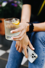 the girl is holding an alcoholic cocktail while sitting on the stairs