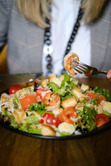a girl eats a Mediterranean salad with seafood