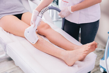 Woman on laser hair removal treatment on leg