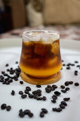 a glass of orange coffee on white table.