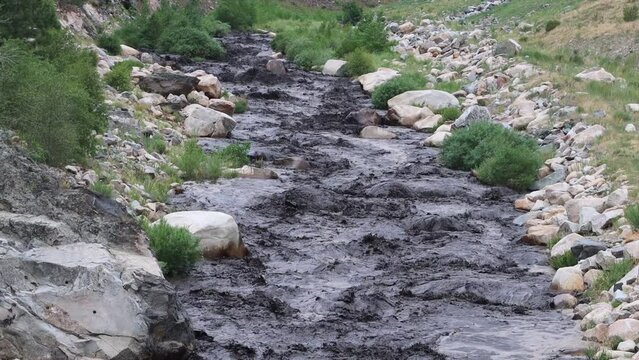Big Thompson river inundated with black soot and mud from a burn scar that became a mudslide July 15, 2022.