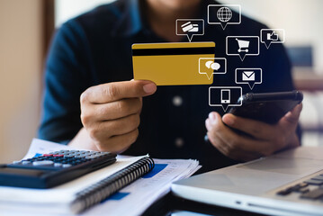 Hands holding credit card and using laptop in office home. Online shopping.