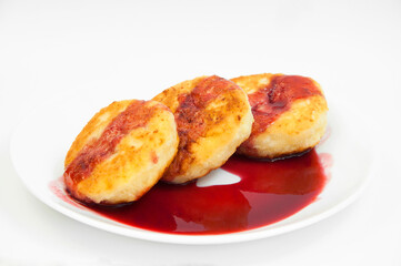 cottage cheese pancakes with raspberry jam in a white plate. light breakfast on the table. fritters with strawberry jam. sweet dessert concept