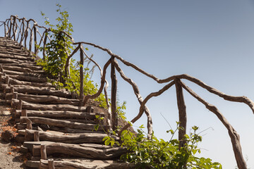 Wooden stairway with railings goes up the rocky coast