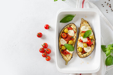 Baked eggplant stuffed with vegetables and mozzarella cheese with addition aromatic herbs. Delicious vegetarian dish recipe. Top view, copy space. Restaurant menu