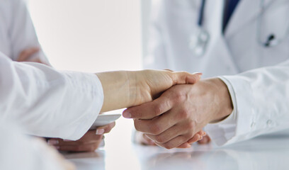Obraz na płótnie Canvas Doctor shaking hands with a male patient in the office
