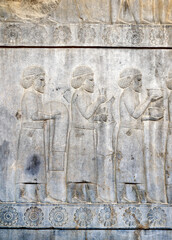 Ancient wall with bas-relief with assyrian foreign ambassadors with gifts and donations, Persepolis, Iran